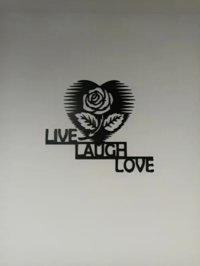 Zidna dekoracija s natpisom Live Laugh Love i cvijetom u obliku srca.